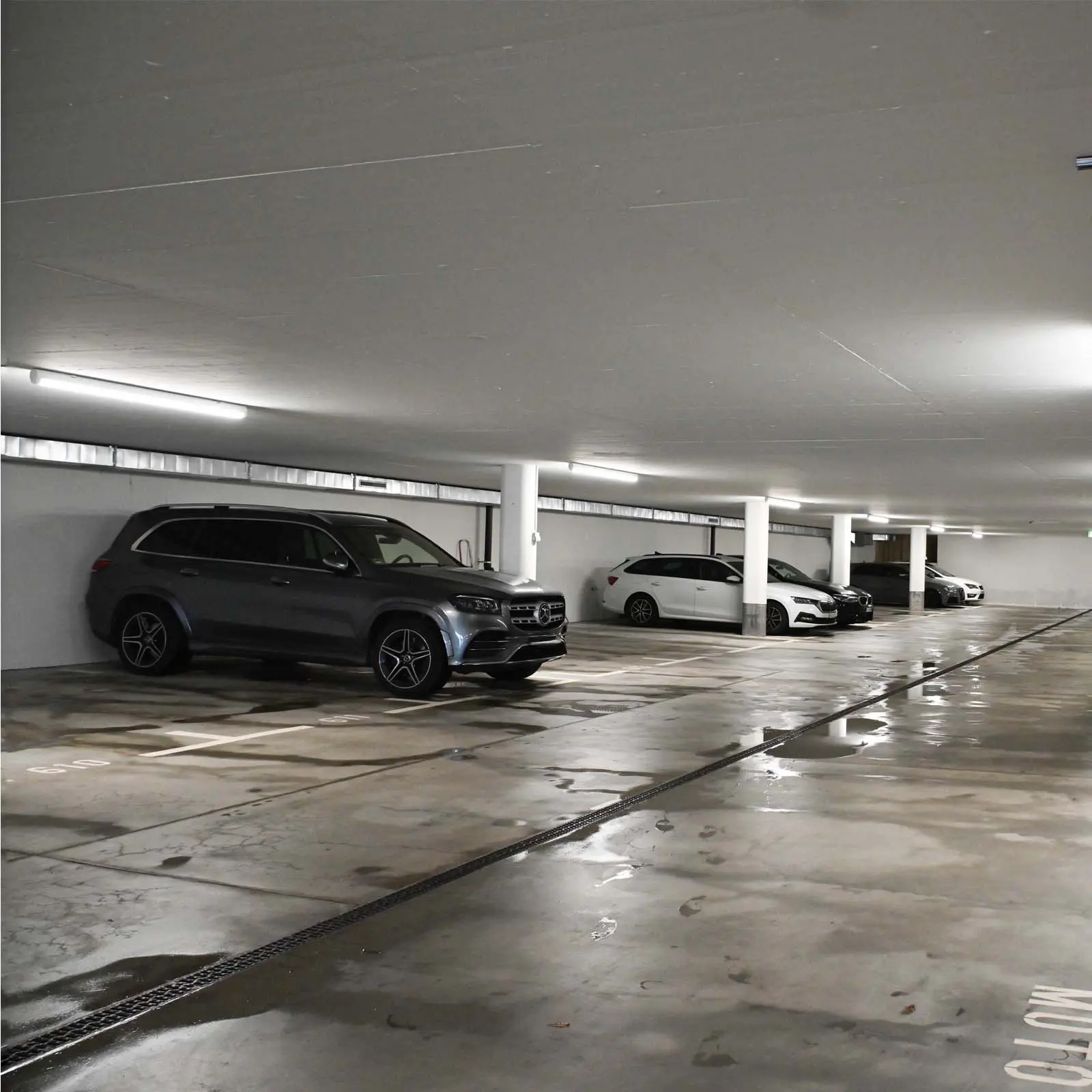 Parking souterrain avec système d’éclairage TRIVALITE et véhicules stationnés