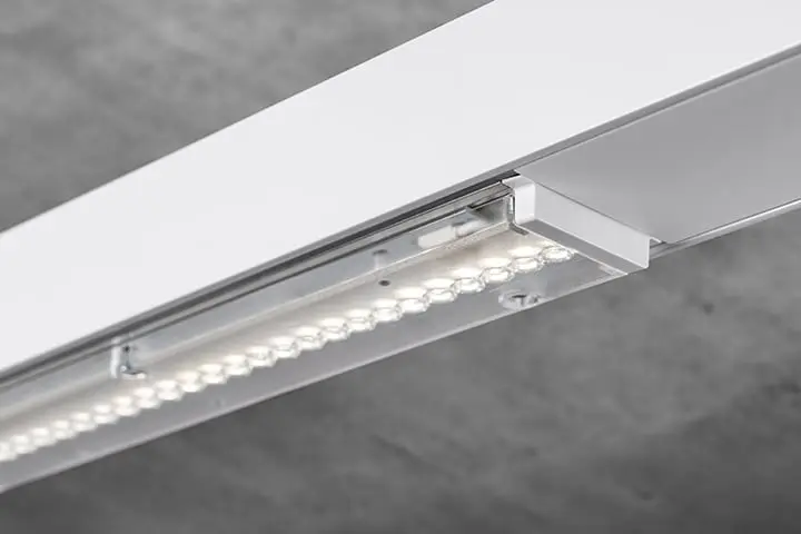 Apparecchio di sistema Lense per il sistema portante Perseus. Questo apparecchio è ideale per ambienti alti, come magazzini o palestre. Grazie all’emissione luminosa diretta verso il basso, la luce raggiunge esattamente i punti in cui è necessaria. Apparecchio di sistema Lense, acceso, per il sistema di supporto Perseus